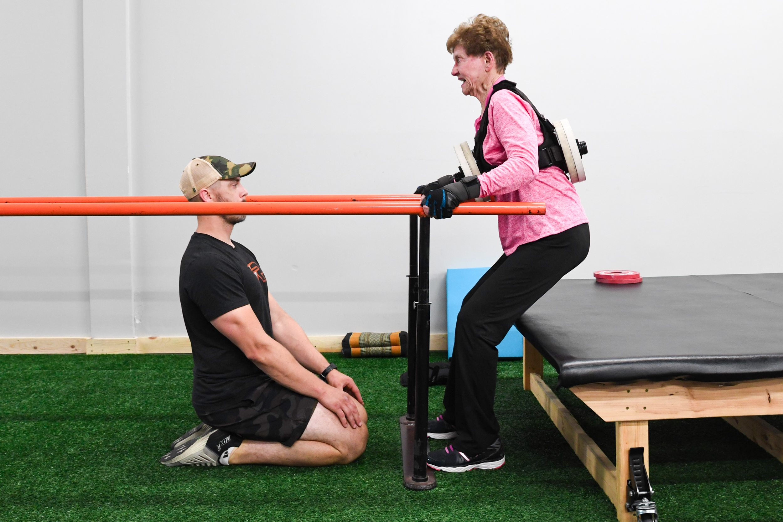 Mary Lou Jensen performs assisted weighted squats.