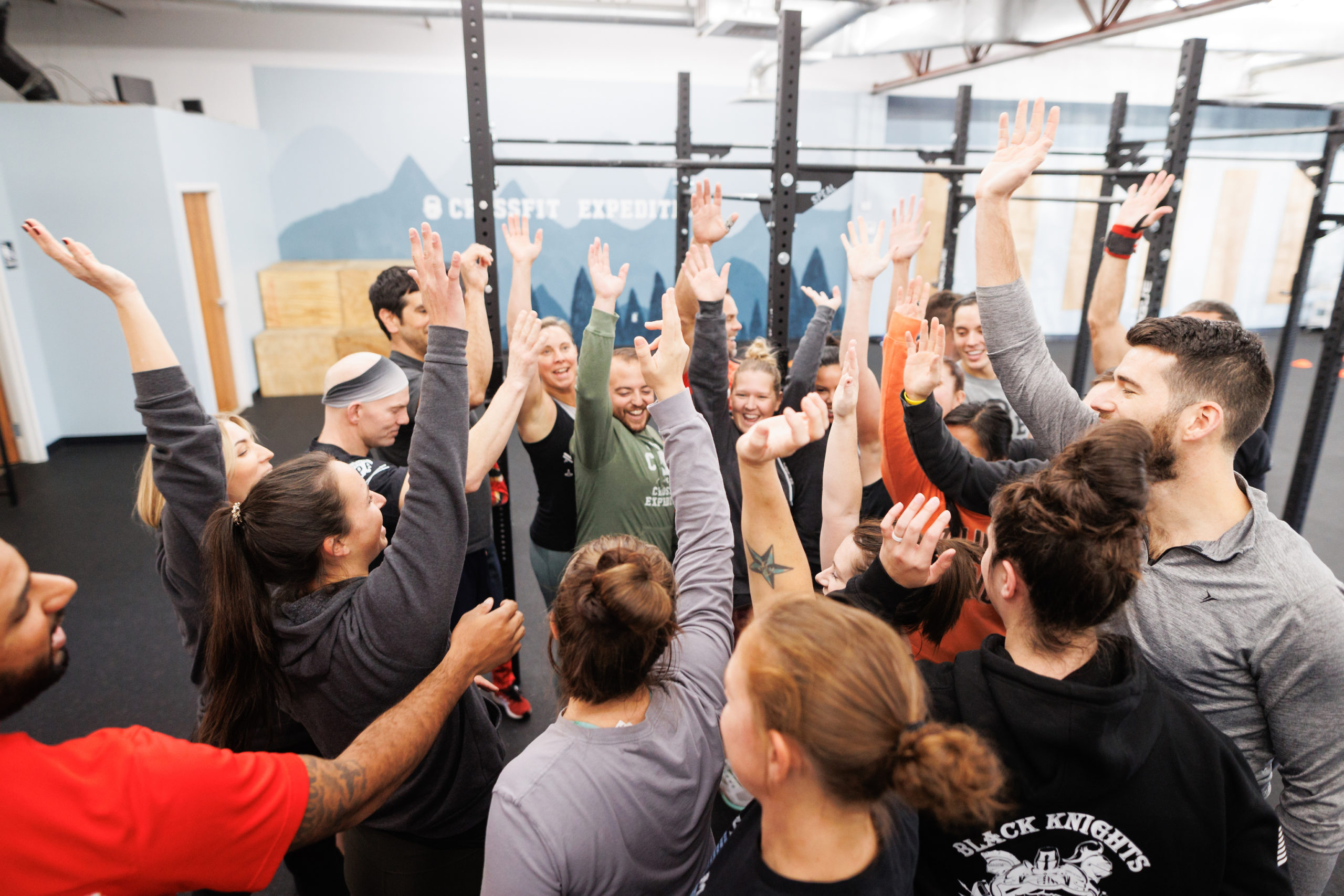 A group of happy CrossFit athletes high-five each other