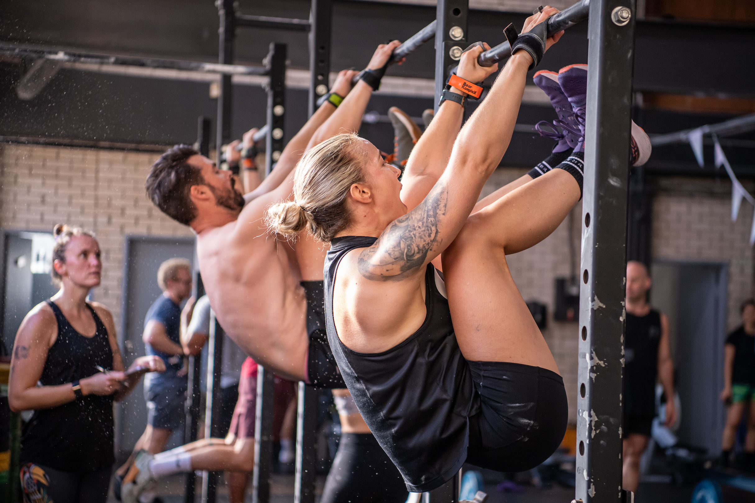 A man and a woman do toes-to-bars side-by-side