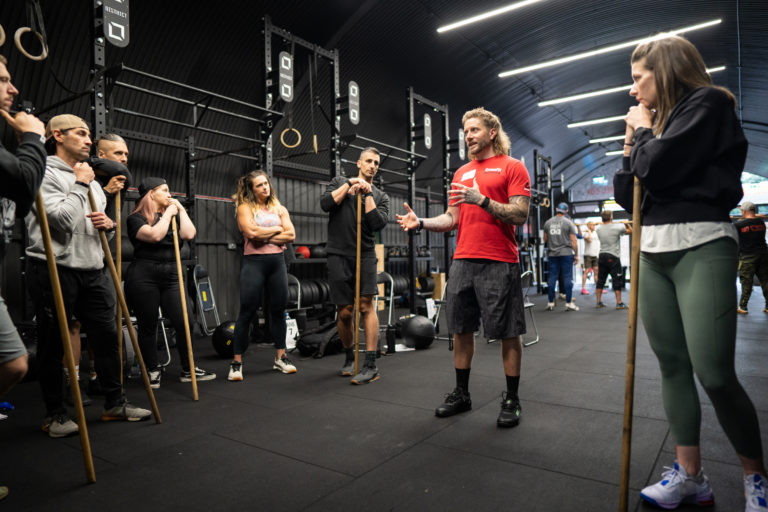 Athletes listen to a CrossFit Seminar Staff Trainer explain a movement.