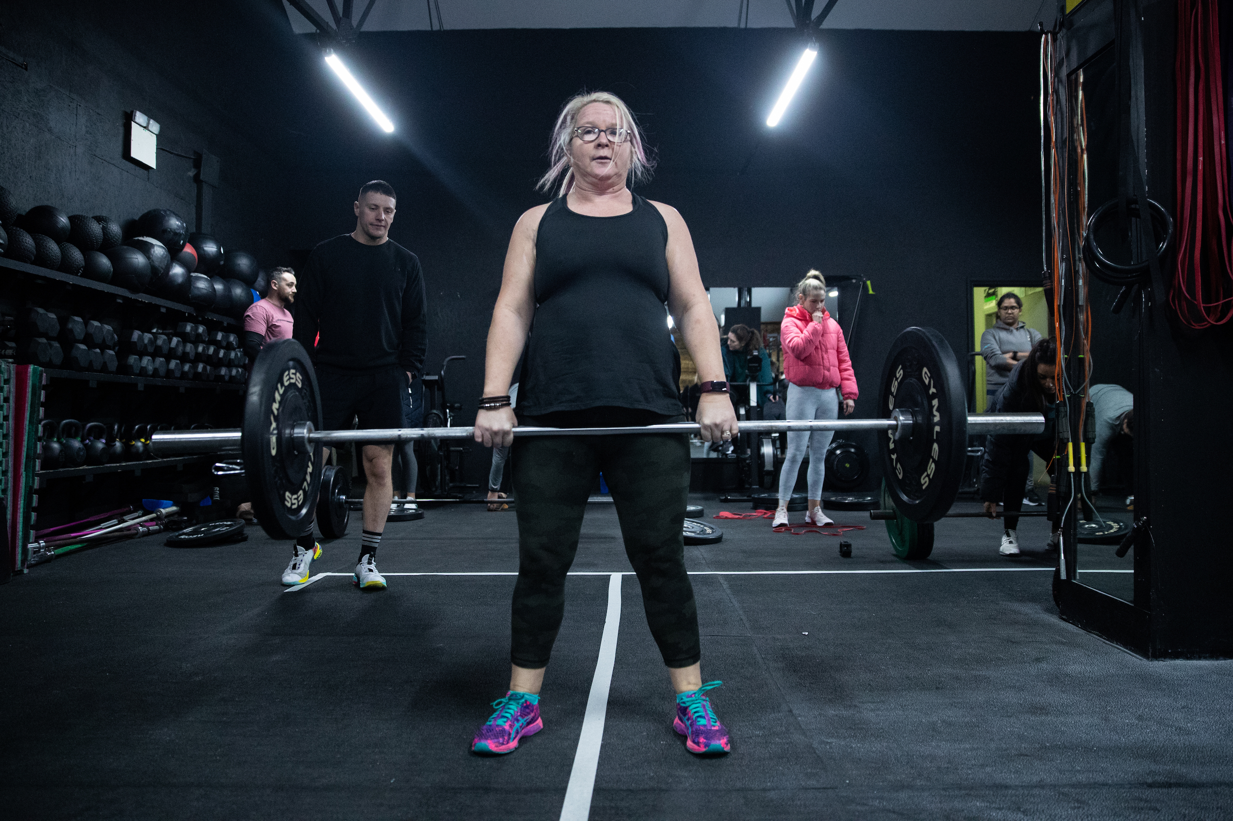 Middle-aged woman at the top of a deadlift.