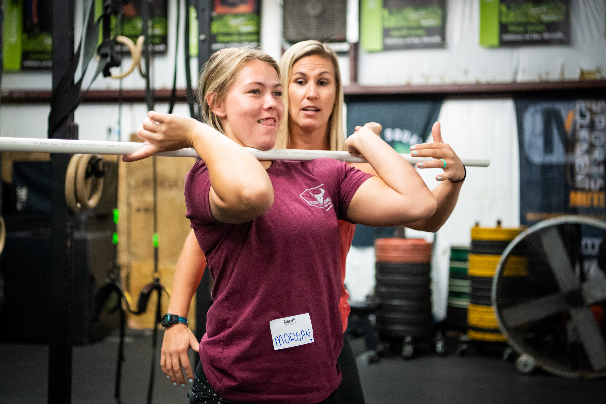 A coach works with an athlete on the front-rack position