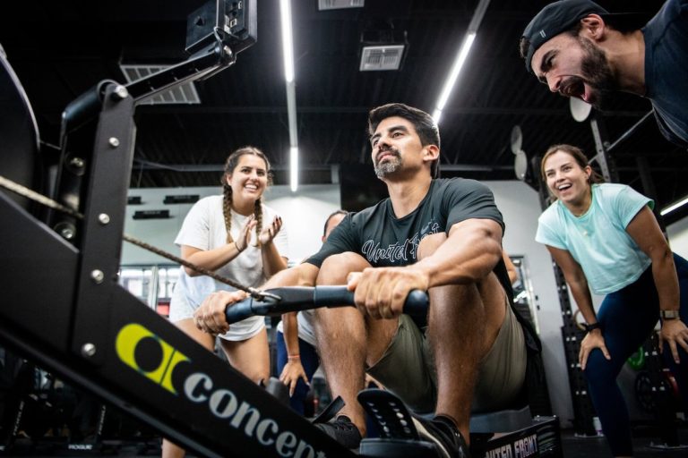 Athlete rowing with athletes cheering