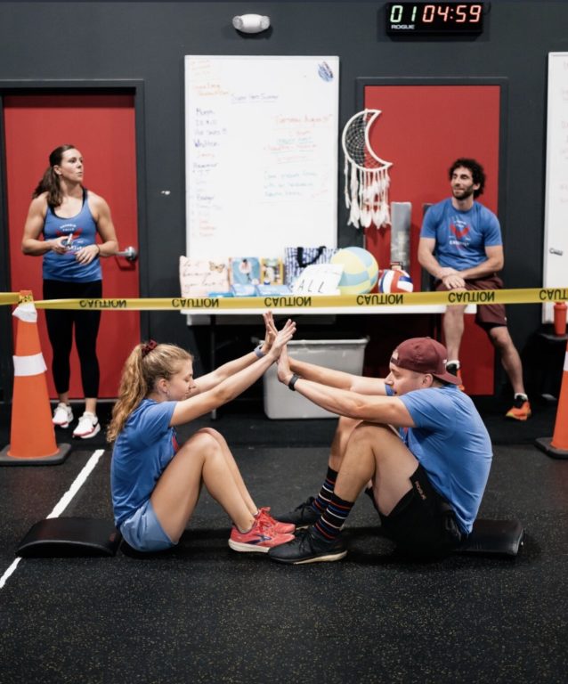 A man and a women high fiving at the top of a sit-up