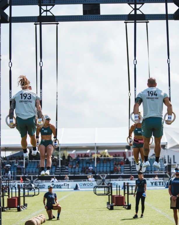 The 2 women and 2 men of Team CrossFit PSC at the top of a ring muscle-up