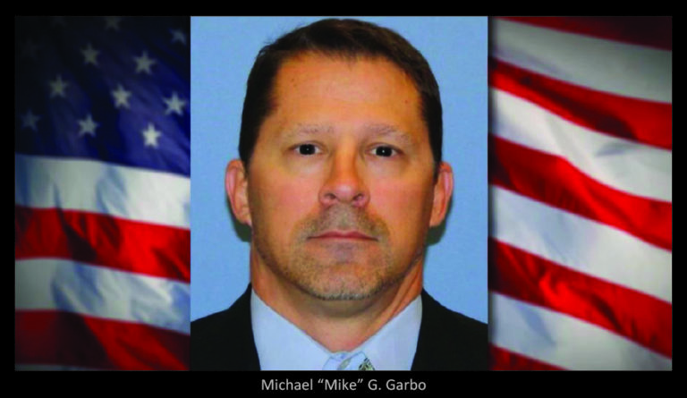 Mike Garbo headshot with American flag in the background