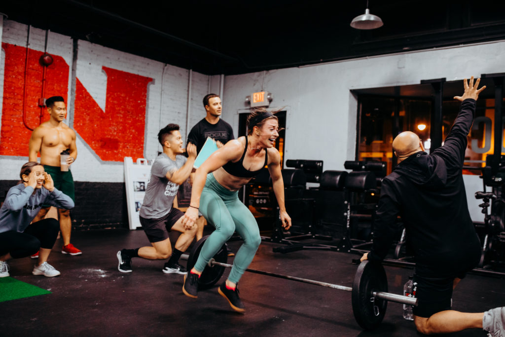 Woman jumping over a barbell