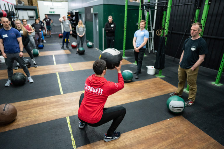 Image of a CrossFit coach demonstrating a med ball clean